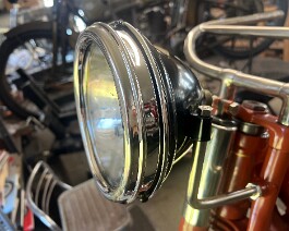 Restored headlight with completely remade headlight rim and brackets in place.